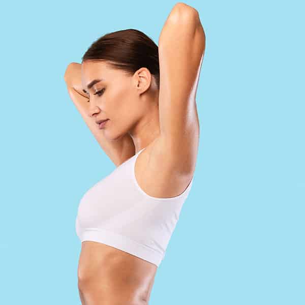 A woman showing off her arms after undergoing renuvion arm lift