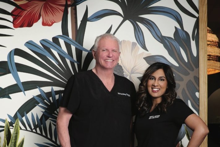 dr. richard bloy and renuka jackson standing together inside of contemporary health center after being named the faces of southwest florida in 2021 from Gulfshore Life magazine
