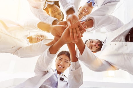 doctors putting their hands together after the latest coronavirus update